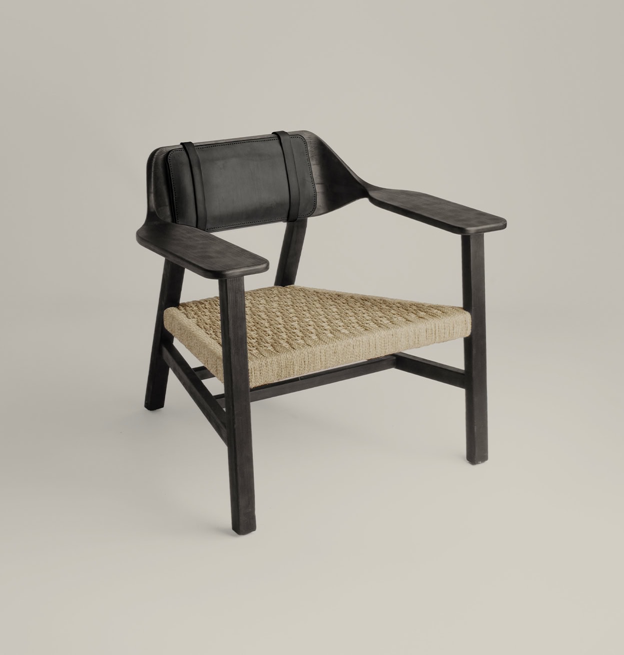 Butaca El Aviador de madera negra con respaldo de cuero y asiento de cuerda tejida natural.