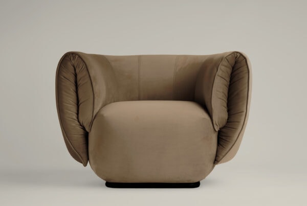 Butaca Veli tapizada en terciopelo beige tostado con brazos envolventes acolchados.